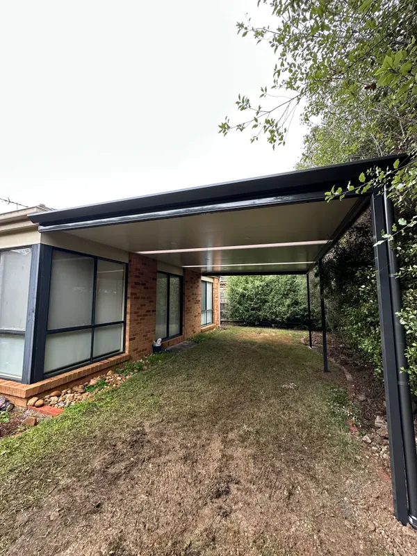Long Stratco Outback Cooldek patio beside a brick home in Seabrook